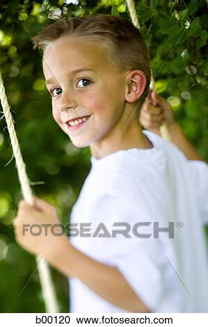 Portrait of a boy swinging on a swing View Large Photo Image Stock Image - Portrait of a boy swinging on a swing. Fotosearch