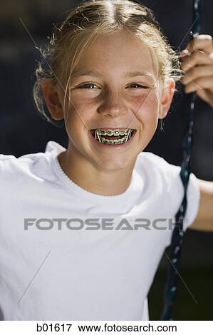 Portrait of a girl sitting on a swing View Large Photo Image Stock Photo - Portrait of a girl sitting on a swing. Fotosearch