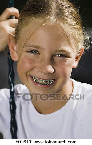 Stock Photo - Portrait of a girl sitting on a swing. Fotosearch