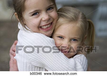 Stock Photograph - Portrait of two sisters hugging. Fotosearch