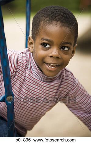 Close-up of a boy playing at playground View Large Photo Image Stock Photograph - Close-up of a boy playing at playground. Fotosearch