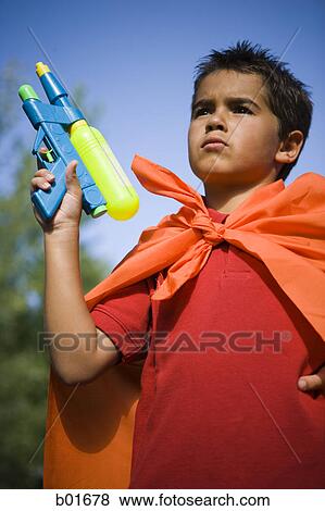 Stock Photo - Low angle view of a boy holding a squirt gun. Fotosearch