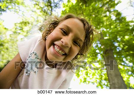 Stock Photo - Low angle view of a girl smiling. Fotosearch
