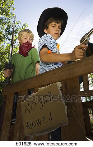 Stock Photo - Low angle view of two boys dressed as cops and robbers. Fotosearch