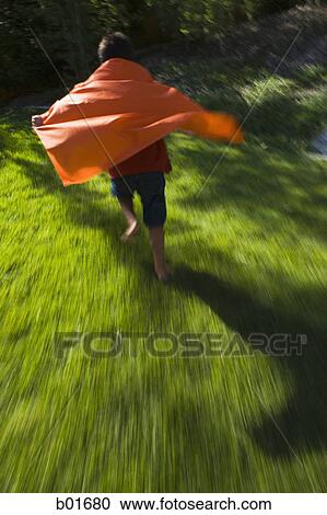 Stock Image - Rear view of a boy wearing a cape. Fotosearch