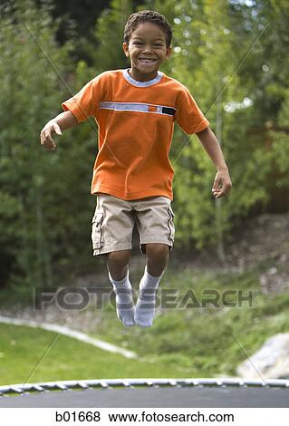 Retrato, de, un, niño, saltar, en, un, trampolín Colección de foto