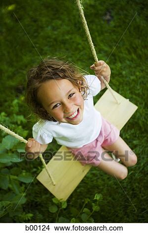 Picture - High angle view of a girl sitting on a swing. Fotosearch