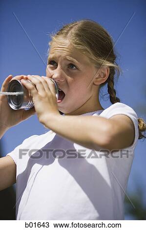 Low angle view of a girl talking into a tin can phone View Large Photo Image Stock Image - Low angle view of a girl talking into a tin can phone. Fotosearch