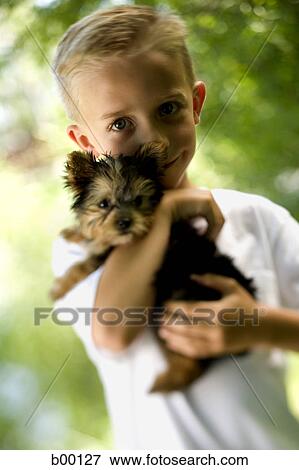 Portrait of a boy carrying a puppy View Large Photo Image Stock Photo - Portrait of a boy carrying a puppy. Fotosearch