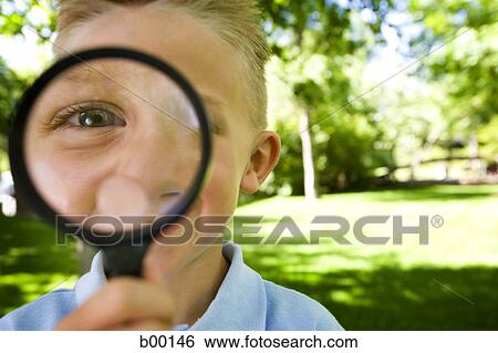 Portrait of a boy looking through a magnifying glass View Large Photo Image Stock Photograph - Portrait of a boy looking through a magnifying glass. Fotosearch