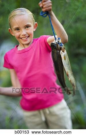 Portrait of a girl holding a fish View Large Photo Image Stock Image - Portrait of a girl holding a fish. Fotosearch