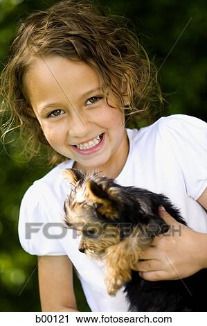 Portrait of a girl holding a puppy View Large Photo Image Stock Image - Portrait of a girl holding a puppy. Fotosearch