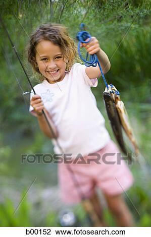 Download Portrait of a girl holding fishing rod and a fish Stock ...