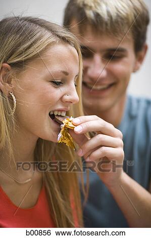 Close-up of a young man feeding a young woman a piece of chocolate View Large Photo Image Stock Photograph - Close-up of a young man feeding a young woman a piece of chocolate. Fotosearch