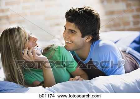Close-up of a young woman and man lying on a bed View Large Photo Image Picture - Close-up of a young woman and man lying on a bed. Fotosearch