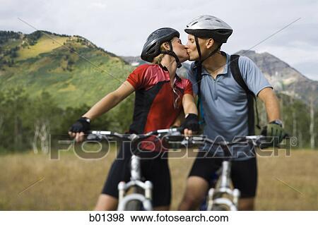 Couple kissing while mountain biking View Large Photo Image Stock Photo - Couple kissing while mountain biking. Fotosearch