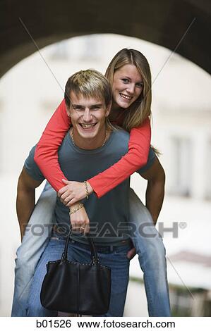 Portrait of a teenage boy giving a piggyback ride to a teenage girl View Large Photo Image Stock Photograph - Portrait of a teenage boy giving a piggyback ride to a teenage girl. Fotosearch