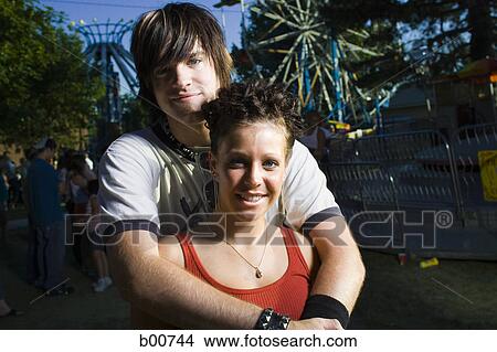 Portrait of a young couple standing in an amusement park View Large Photo Image Picture - Portrait of a young couple standing in an amusement park. Fotosearch
