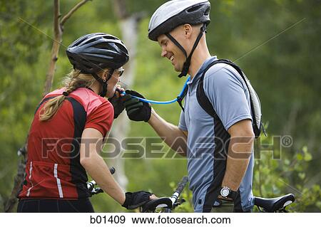 Rear view of a couple mountain biking View Large Photo Image Stock Photo - Rear view of a couple mountain biking. Fotosearch