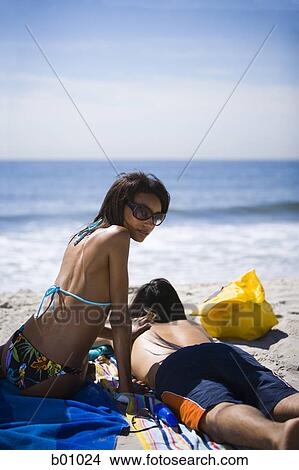 Picture - Rear view of a young couple on the beach. Fotosearch