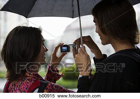 Rear view of a young man with a young woman looking at a camera screen View Large Photo Image Stock Photography - Rear view of a young man with a young woman looking at a camera screen. Fotosearch