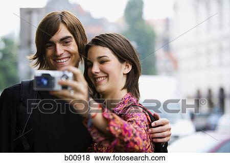 Teenage girl with a young man taking a photograph of themselves View Large Photo Image Stock Photo - Teenage girl with a young man taking a photograph of themselves. Fotosearch