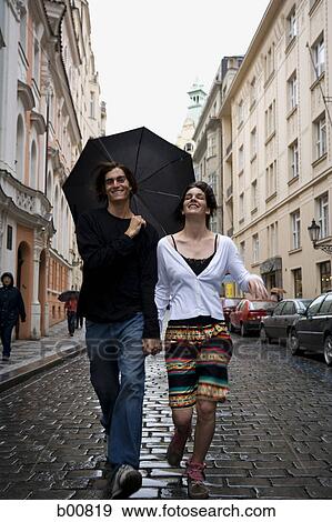 Young couple walking down a cobblestone street View Large Photo Image Stock Photo - Young couple walking down a cobblestone street. Fotosearch