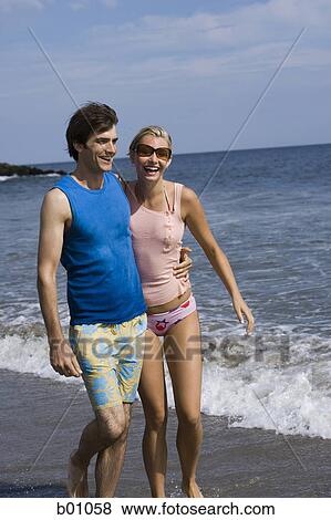 Young couple walking on the beach View Large Photo Image Stock Photo - Young couple walking on the beach. Fotosearch