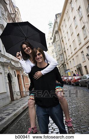 Young man giving a piggyback ride to a teenage girl View Large Photo Image Stock Image - Young man giving a piggyback ride to a teenage girl. Fotosearch