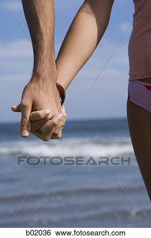 Close-up of a man and woman holding hands View Large Photo Image Stock Photograph - Close-up of a man and woman holding hands. Fotosearch