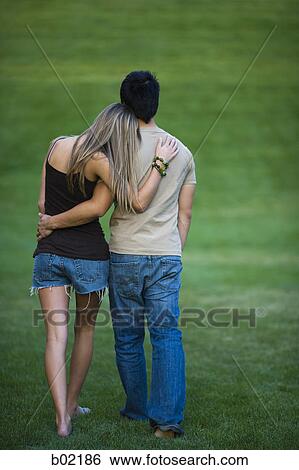 Close-up of a young man and woman walking in a park View Large Photo Image Stock Photograph - Close-up of a young man and woman walking in a park. Fotosearch