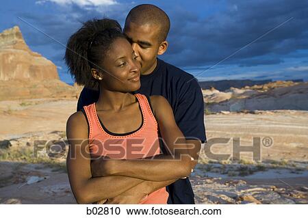 Stock Image - Low angle view of a young couple standing. Fotosearch
