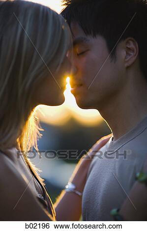 Portrait of a young man and woman kissing View Large Photo Image Stock Photograph - Portrait of a young man and woman kissing. Fotosearch