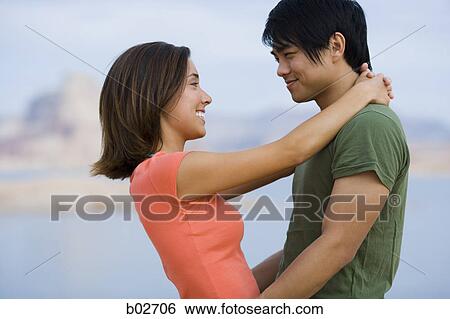 Stock Photograph - Profile of a young couple looking at each other. Fotosearch
