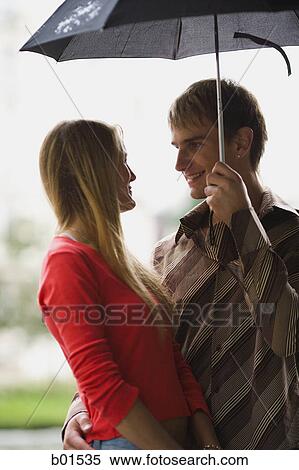 Teenage couple under an umbrella View Large Photo Image Stock Photography - Teenage couple under an umbrella. Fotosearch