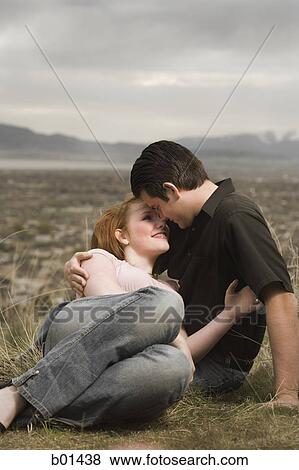 Young couple kissing in a meadow View Large Photo Image Stock Photo - Young couple kissing in a meadow. Fotosearch
