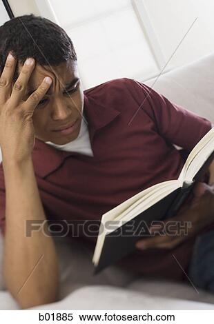 Stock Photography - Close-up of a young man reading a book. Fotosearch