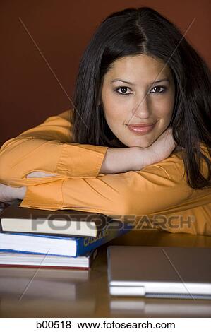 Stock Photo - Portrait of a young woman resting her head on her hand. Fotosearch