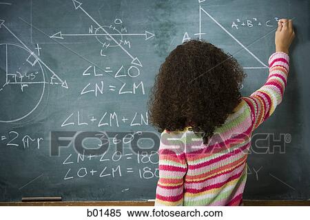 Stock Photography - Rear view of a girl writing on a blackboard. Fotosearch