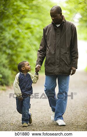 Father walking with his son outdoors View Large Photo Image Stock Image - Father walking with his son outdoors. Fotosearch