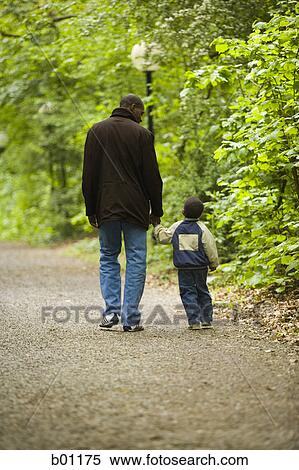Father with his son walking on a path View Large Photo Image Stock Photography - Father with his son walking on a path. Fotosearch