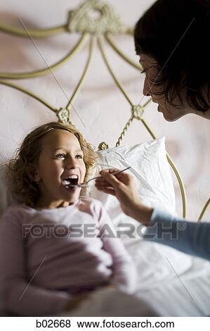 High angle view of a mother feeding her daughter View Large Photo Image Stock Photo - High angle view of a mother feeding her daughter. Fotosearch
