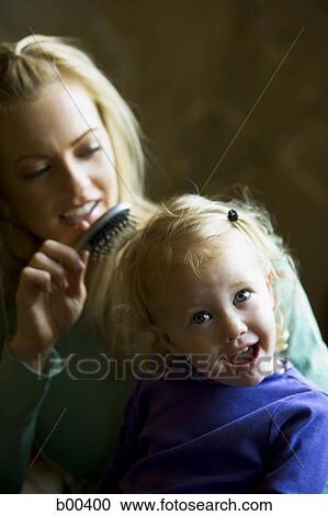Mother brushing her daughter's hair View Large Photo Image Stock Image - Mother brushing her daughter's hair. Fotosearch