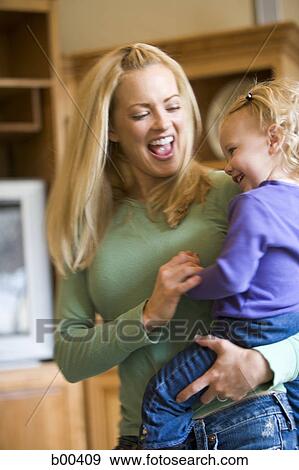 Stock Photo - Mother carrying her daughter. Fotosearch