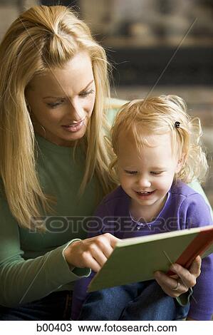 Mother reading a book with her daughter View Large Photo Image Stock Image - Mother reading a book with her daughter. Fotosearch