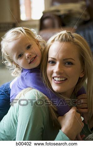 Portrait of a daughter riding piggyback on her mother View Large Photo Image Stock Image - Portrait of a daughter riding piggyback on her mother. Fotosearch