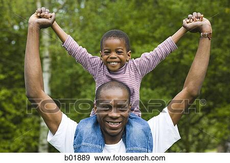 Portrait of a father carrying his son on his shoulders View Large Photo Image Stock Photo - Portrait of a father carrying his son on his shoulders. Fotosearch