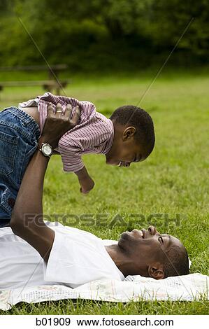 Portrait of a father lifting his son View Large Photo Image Stock Photo - Portrait of a father lifting his son. Fotosearch