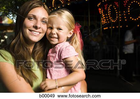 Portrait of a mother carrying her daughter View Large Photo Image Stock Photo - Portrait of a mother carrying her daughter. Fotosearch