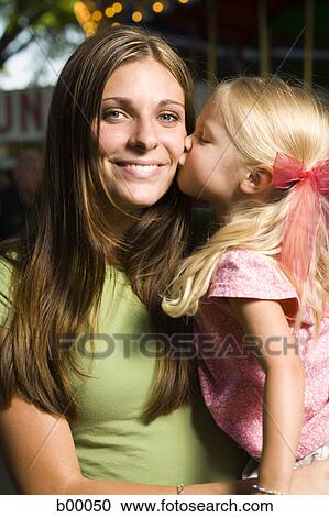 Portrait of a young woman being kissed by her daughter View Large Photo Image Stock Image - Portrait of a young woman being kissed by her daughter. Fotosearch